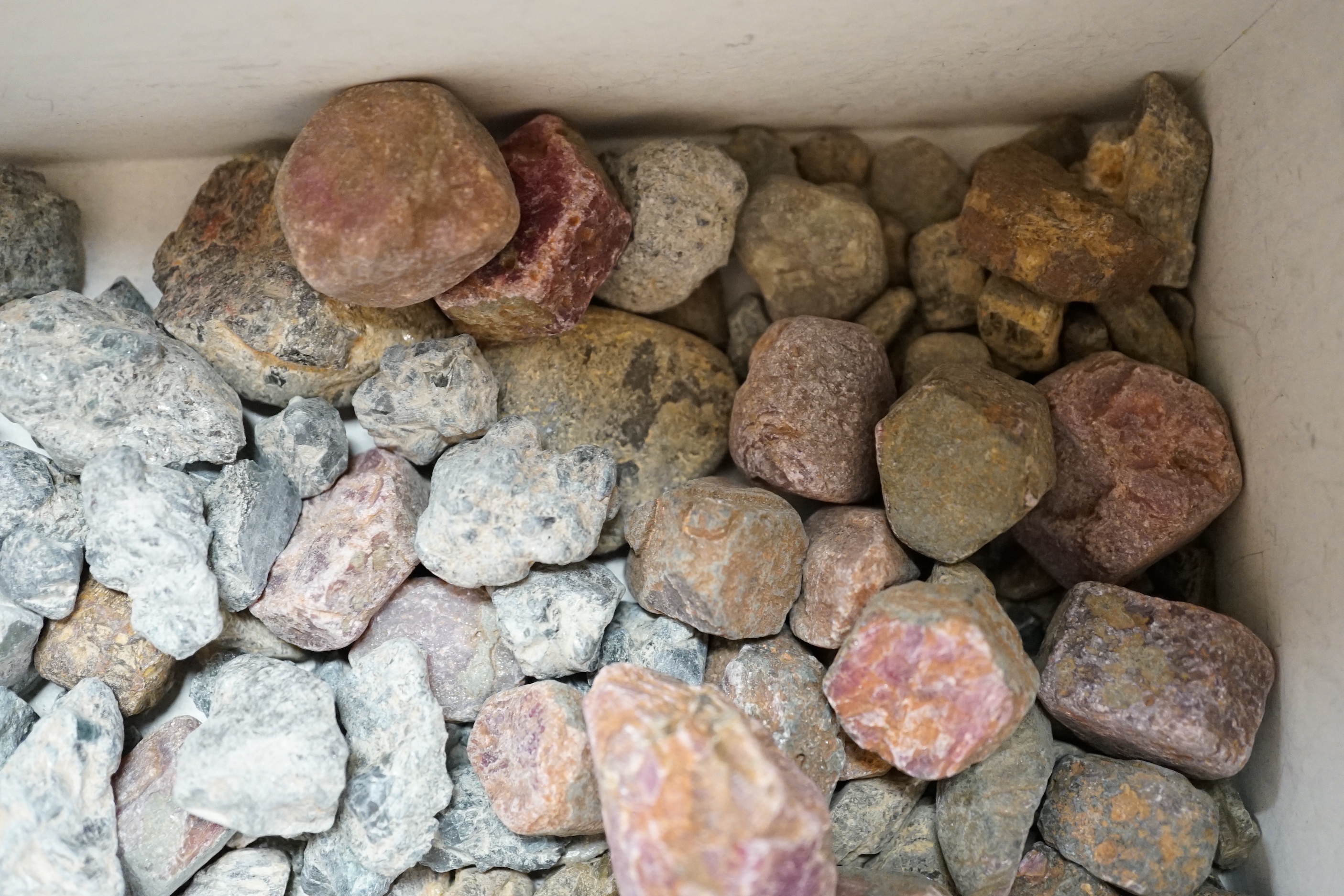 A quantity of assorted unpolished and uncut stones including chrysoberyl and corundum.